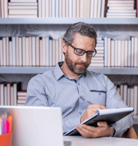 A registrar checks grades on a transcript while Afar translation services keep course titles and credits consistent.