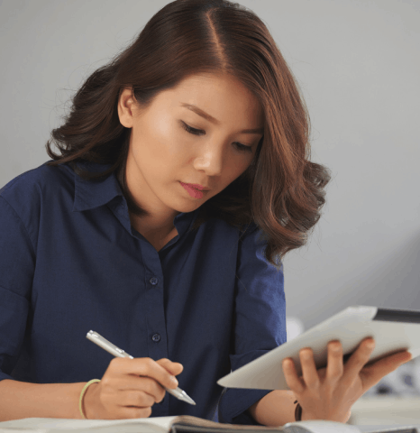 A student compares a diploma and its Chinese translation, using chinese translation services new york for admissions packets.