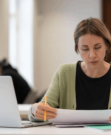 A student checks a Czech transcript against the English draft as Czech translation services format academic records.