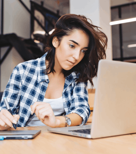 A student reviews a translated university transcript, using Finnish translation services to match grades, dates, and names.