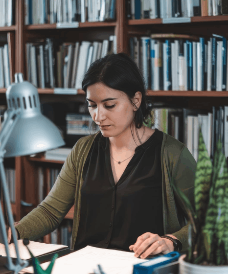 A grad student checks citations in a translated journal draft, using Indonesian translation services for academic research.