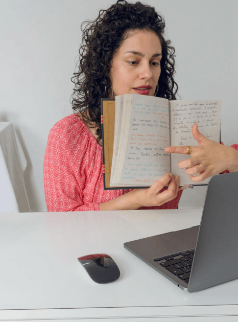 A student hands over a transcript for academic Marathi translation services while an editor checks course titles and grades.