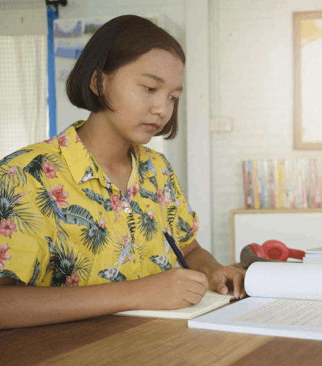 A student reviews translated transcripts and a diploma packet as Burmese Translation Services deliver accuracy.