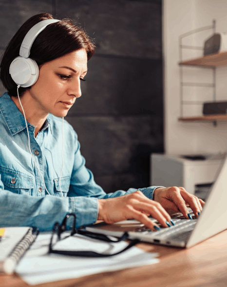A caption specialist runs post production captioning services QA, checking accurate timing for accessibility on a laptop.