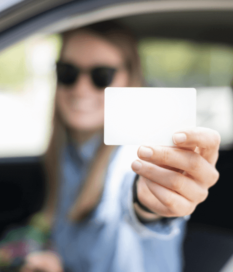 A girl holding her driving license, which is accurately translated at an affordable cost. 