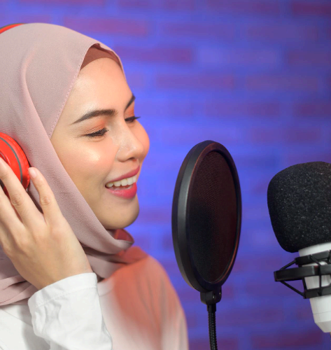A native Urdu artist records clear audio content in a studio booth, delivering Urdu Voice Over Services with fast review.