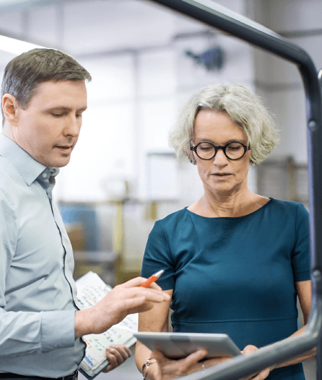 Two partner firms review a bilingual supply agreement, using manufacturing translation services for B2B partners and vendors.