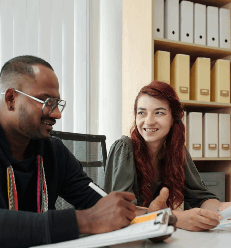 Two colleagues compare English and Kiswahili drafts to refine tone, using Swahili translation services in a review loop.