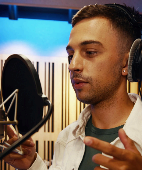 A voice artist records engaging multilingual content in a studio, delivering language voice over services for India.