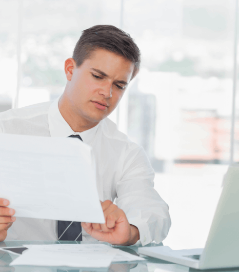 A manager reviews redacted files in a secure portal, using corporate document translation services for business use.