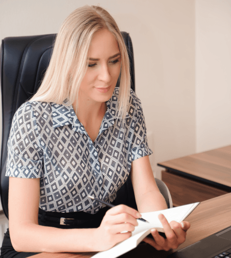 A translator edits a Lithuanian and English contract on screen, providing Lithuanian translation services for business use.