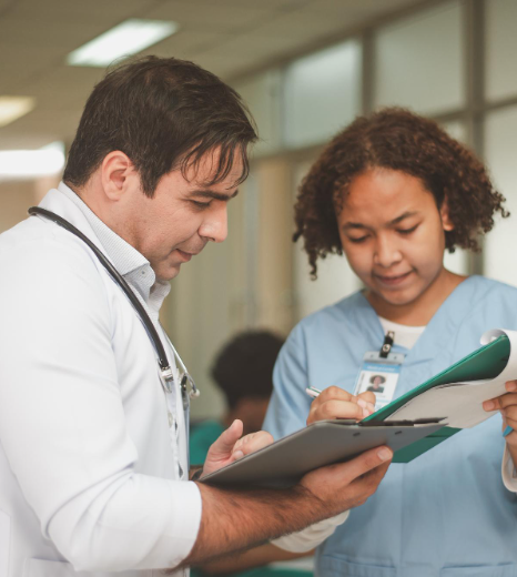 A certified specialist compares a chart and bilingual report during medical records translation in New York at a desk.