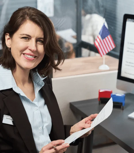 A translator signs a certification letter beside official documents as overnight translation services complete final checks.