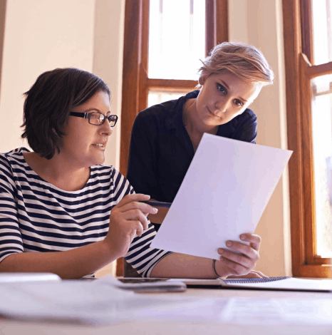 An accountant and translator check ledgers as Swedish translation services deliver a certified financial document set.