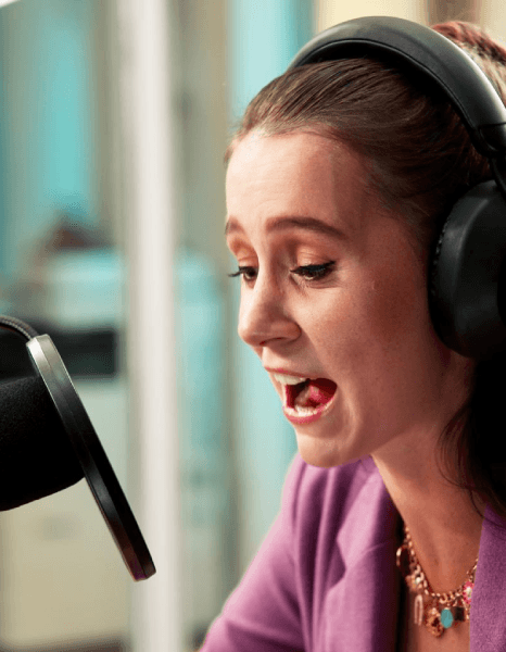 A client reviews two regional Polish accents on headphones, approving Polish Voice Over Services for a local training video.
