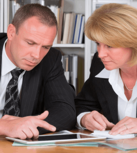 Two lawyers compare a bilingual contract draft, using Malay translation services to keep clauses and obligations consistent.