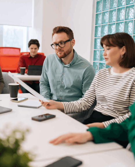 A procurement team compares vendor bids on laptops while Basque translation services standardize terms for approval.