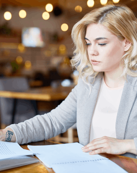 A manager compares a bilingual contract draft, showing Finnish translation services for business terms and dates.