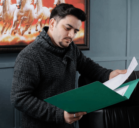 A specialist fixes layout and fonts in a bilingual brochure, using Afar translation services to keep multilingual formatting.