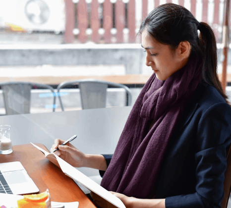 A reviewer proofreads a Gujarati brochure using Gujarati Translation Services, checking tone, formatting, and consistency.