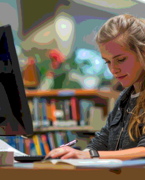 A student timestamps a lecture recording in a laptop editor, using Polish Transcription Services for academic notes.