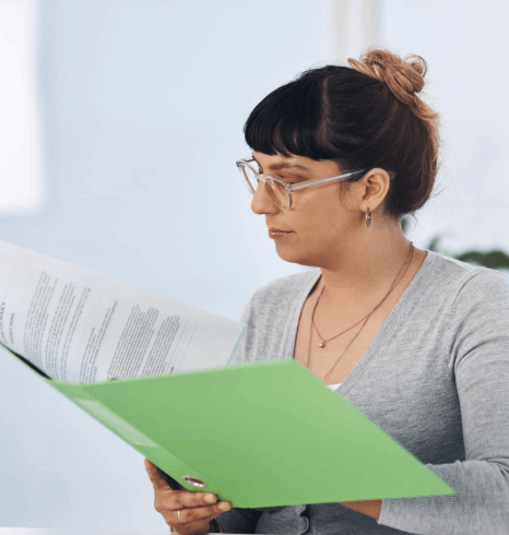 An editor compares a safety manual layout as flemish translation services keep technical terms and numbering consistent.