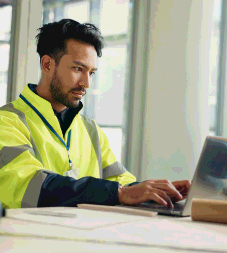 An engineer edits a machinery user manual while Greek Translation Services deliver technical terms for safe operation.