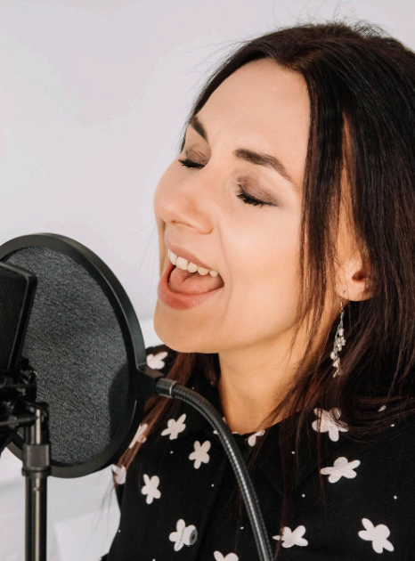 A narrator records Italian Voice Over Services for a technical manual, reading specifications clearly into a studio mic.