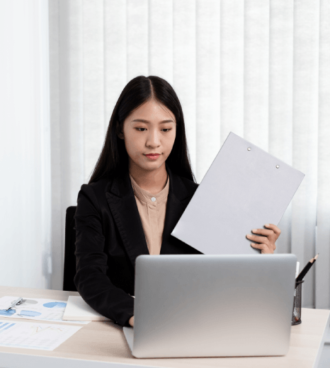 A translator compares bilingual ledgers and tax tables, delivering Accounting Translation Services for multilingual records.