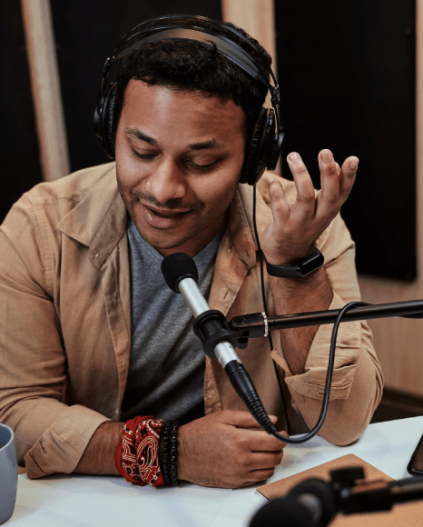 A narrator records multilingual audio guide lines for a voice over service for museum tour in a sound booth.