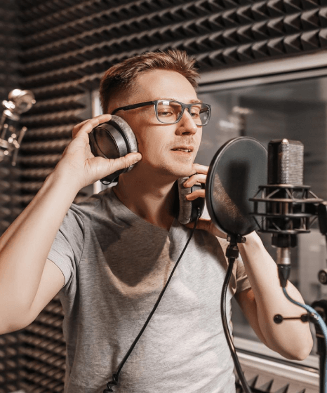 A narrator records commanding brand narration in a studio booth using Deep Voiceover Services for a confident tone.