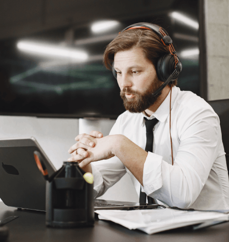 A narrator records E-learning Voiceover Services in a studio while an online learning module plays on a monitor.