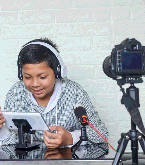 A producer tests Tagalog Subtitling Services on online-offline media, previewing captions on phone, laptop, and TV.