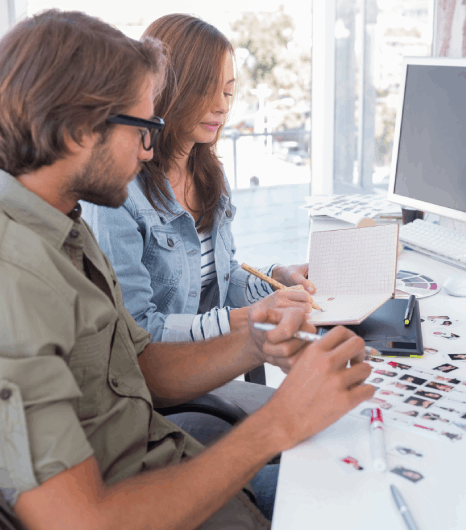 Two prepress specialists uses farsi typesetting services for print and digital PDFs, checking fonts and margins.