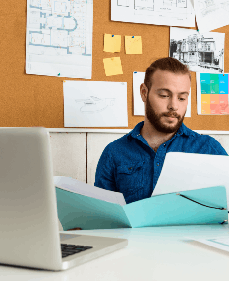 A designer proofreads print and digital pages on dual monitors as Book Typesetting Services refine margins and spacing.