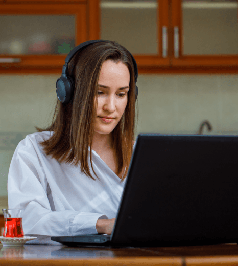 An employee watches a training clip in a noisy office as corporate video captioning services boost retention.
