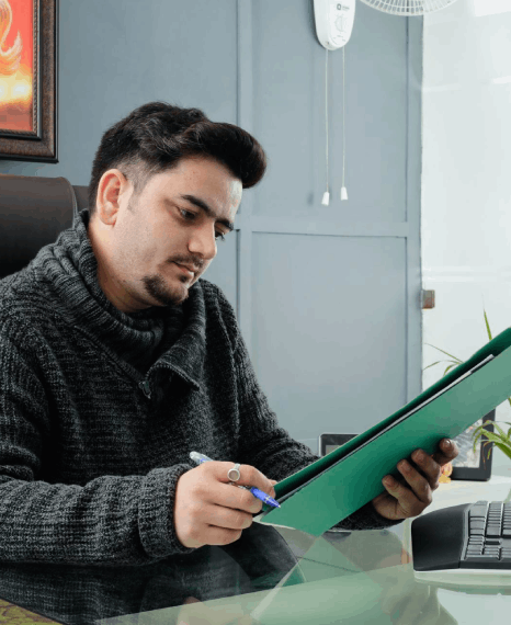 A registrar reviews a school record while Gujarati Translation Services adapt Charotari terms for a local audience.