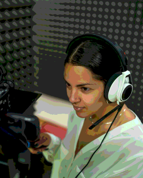 A voice actor records Spanish Voice Over Services in a studio session as an engineer monitors audio for a video.