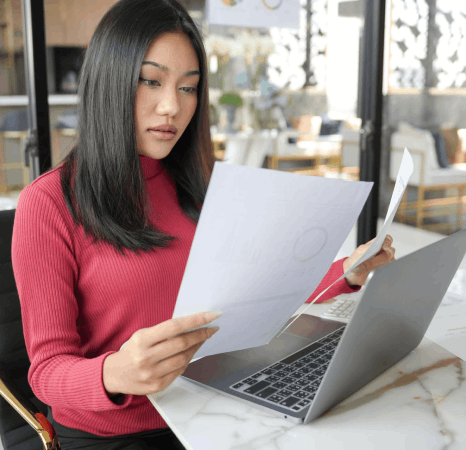 A skilled language specialist proofreads a Vietnamese report printout, using Vietnamese Translation Services for accuracy.