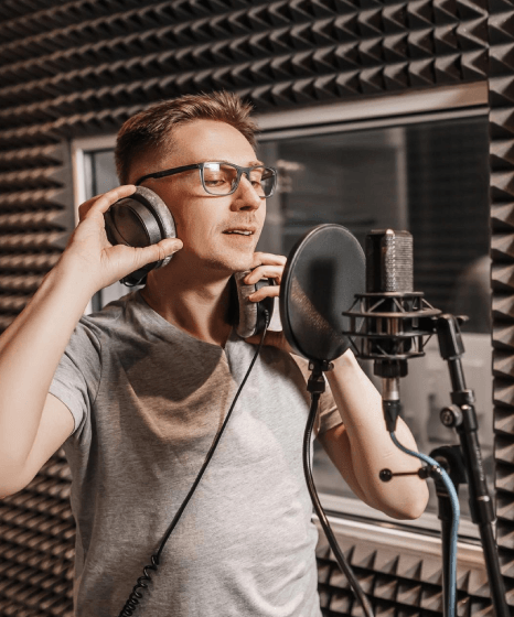 A native talent records in a studio for voice over service for museum tour, delivering warm, noise-free narration.