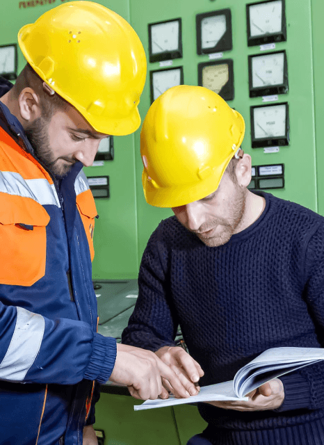 An engineer reviews a machine guide while Georgian translation services match measurements, parts lists, and warnings.