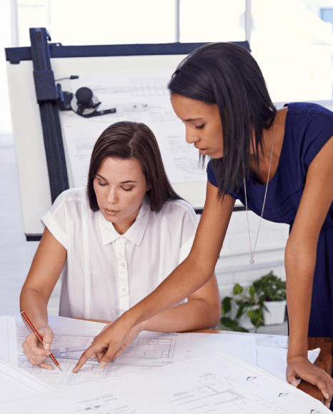 A project lead reviews translated blueprints, using manufacturing translation services to match technical symbols and units.