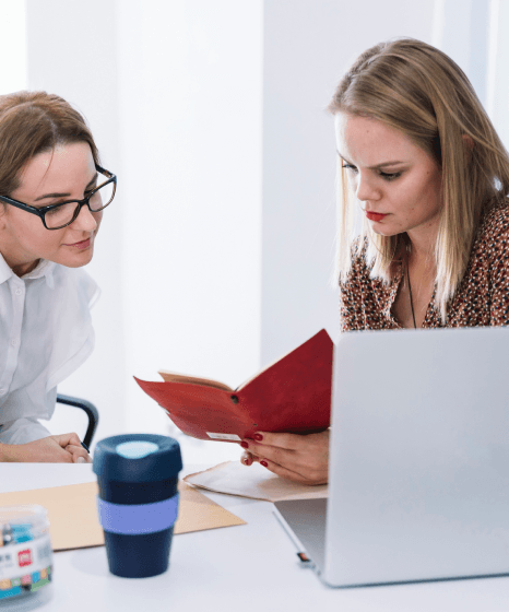 A writer checks screenshots and step lists as Danish translation services update a technical user guide for a new release.