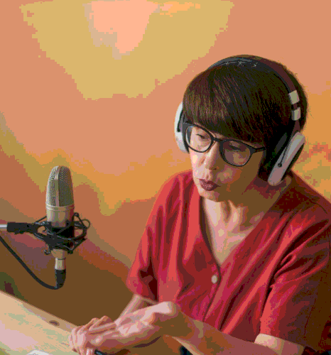 A learning designer checks training slides while Spanish Voice Over Services narration is recorded for clear, steady pacing.