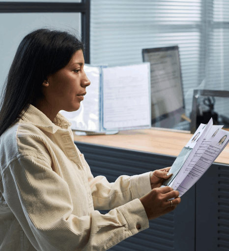An applicant checks a USCIS packet while Afar translation services match names, dates, and official seals exactly.