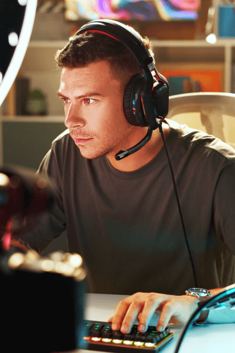 A director listens to audition clips on a laptop, comparing video game voice over services from several voice over agencies.