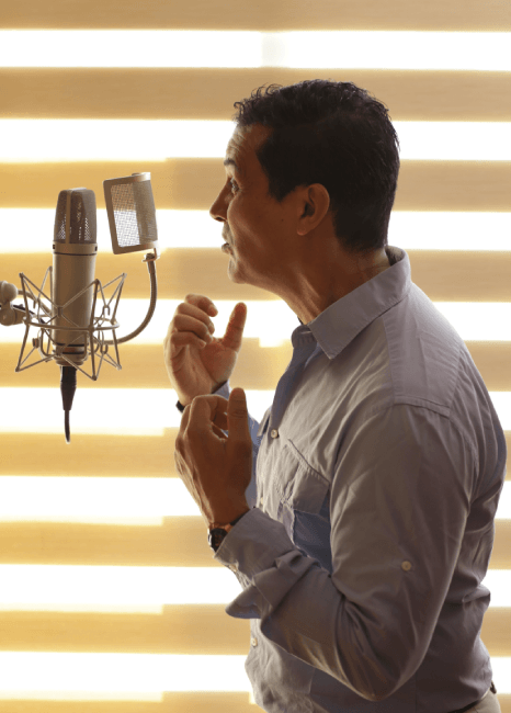 A producer directs a deep voice session for Voice-Over Services in an ad studio, shaping a bold brand message for a spot.