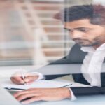 A professional translator working with a birth certificate to translate the different language