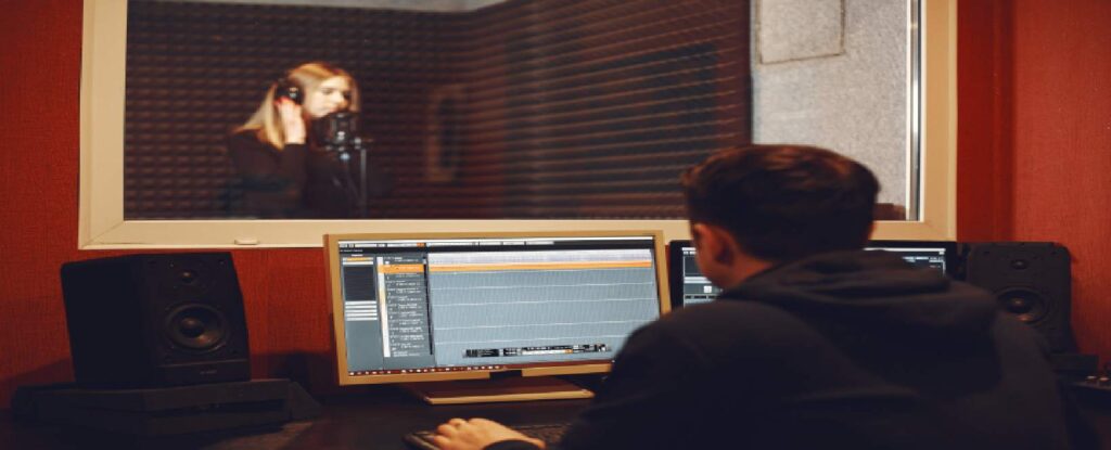 A person working on audio to deliver audio description for visual impairments uses it to enhance their viewing experience.