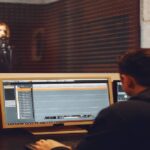 A person working on audio to deliver audio description for visual impairments uses it to enhance their viewing experience.